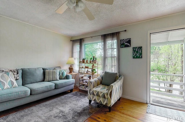 living room featuring ceiling fan, plenty of natural light, a textured ceiling, and hardwood / wood-style floors