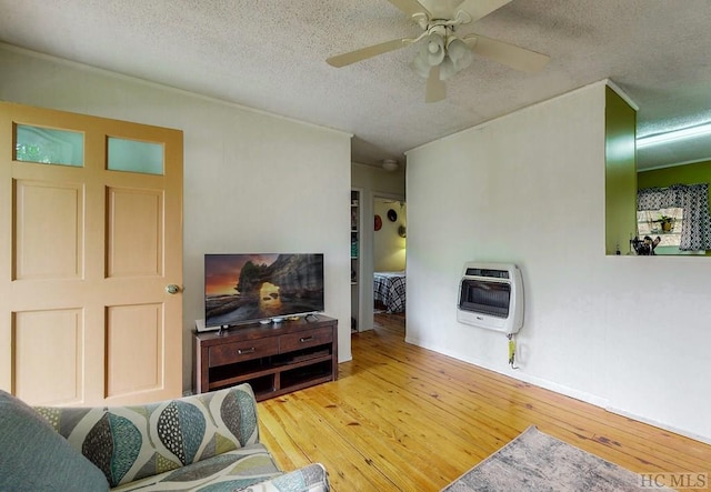 living room featuring heating unit, wood-type flooring, a textured ceiling, and ceiling fan