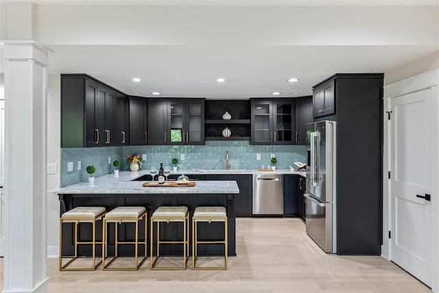 227 Sherwood Forest Rd, Highlands, NC 28741 - kitchen featuring appliances with stainless steel finishes, a peninsula, glass insert cabinets, backsplash, and a breakfast bar