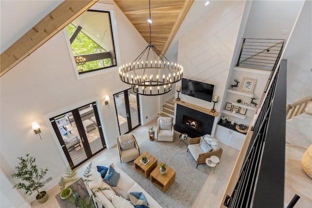 227 Sherwood Forest Rd, Highlands, NC 28741 - living room with a chandelier, high vaulted ceiling, built in shelves, a premium fireplace, and french doors