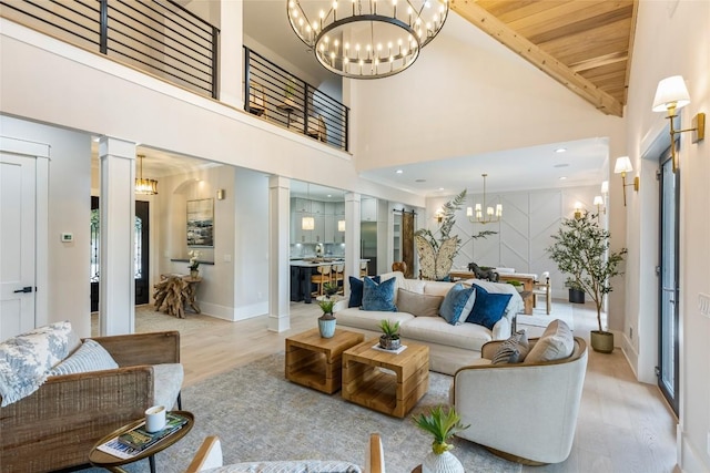 227 Sherwood Forest Rd, Highlands, NC 28741 - living room featuring a chandelier, decorative columns, wood finished floors, and high vaulted ceiling