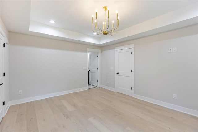 227 Sherwood Forest Rd, Highlands, NC 28741 - spare room featuring a chandelier, a raised ceiling, light wood-style flooring, recessed lighting, and baseboards
