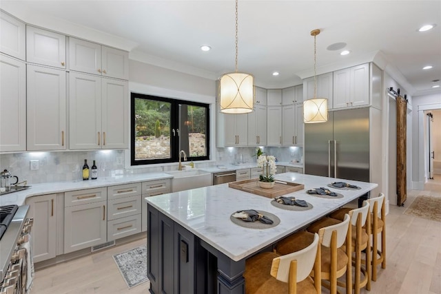 227 Sherwood Forest Rd, Highlands, NC 28741 - kitchen featuring stainless steel appliances, a barn door, decorative backsplash, a kitchen island, and light stone countertops