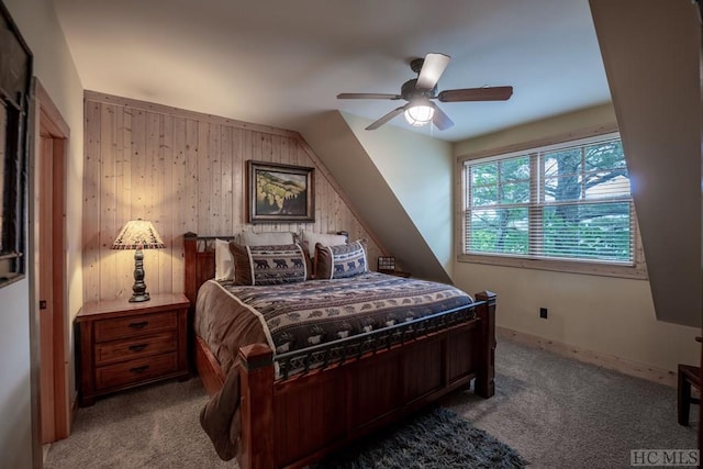 carpeted bedroom featuring ceiling fan and wooden walls