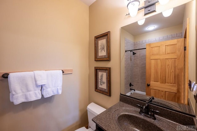 full bathroom with toilet, tiled shower / bath, and vanity