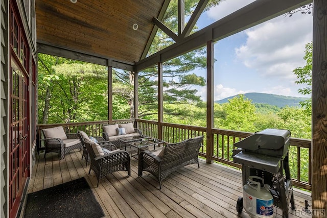 sunroom / solarium featuring a mountain view and lofted ceiling