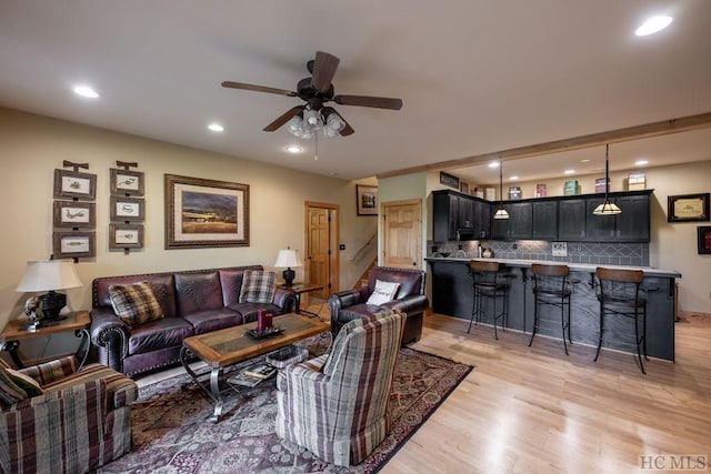 living room featuring ceiling fan and light hardwood / wood-style flooring