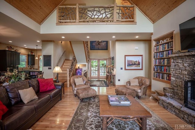 living room with high vaulted ceiling, a wealth of natural light, wooden ceiling, and a stone fireplace