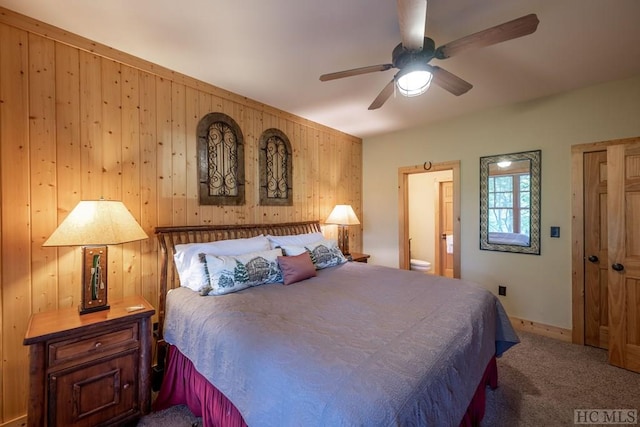 bedroom featuring ceiling fan, carpet, and wood walls