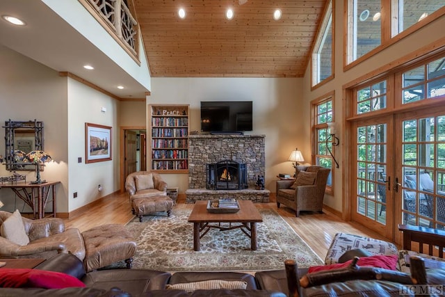 living room featuring a fireplace, light hardwood / wood-style flooring, high vaulted ceiling, and wood ceiling