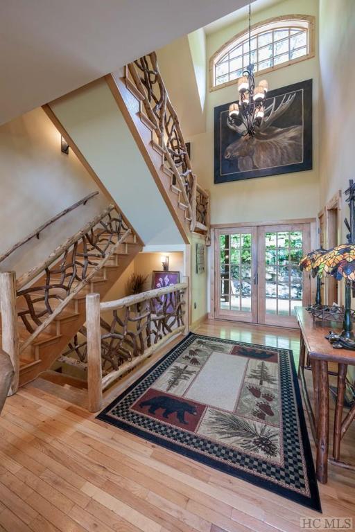 interior space featuring a notable chandelier, a towering ceiling, french doors, and hardwood / wood-style floors