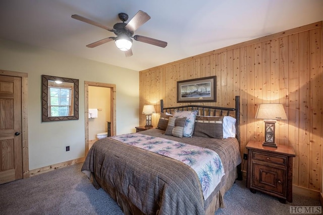 bedroom featuring ceiling fan, connected bathroom, carpet floors, and wooden walls