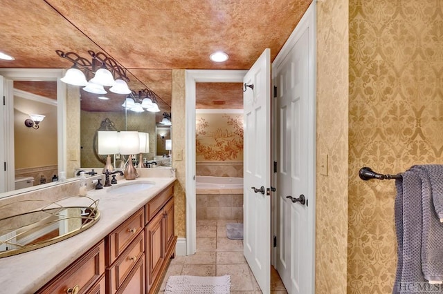 bathroom featuring ornamental molding, vanity, and a relaxing tiled tub