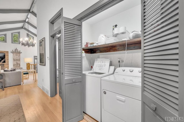 washroom featuring light wood-type flooring, an inviting chandelier, and washing machine and clothes dryer