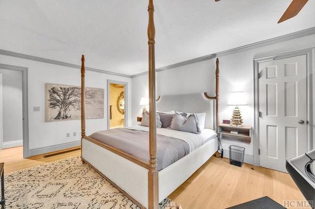 bedroom with ceiling fan, ornamental molding, and hardwood / wood-style floors