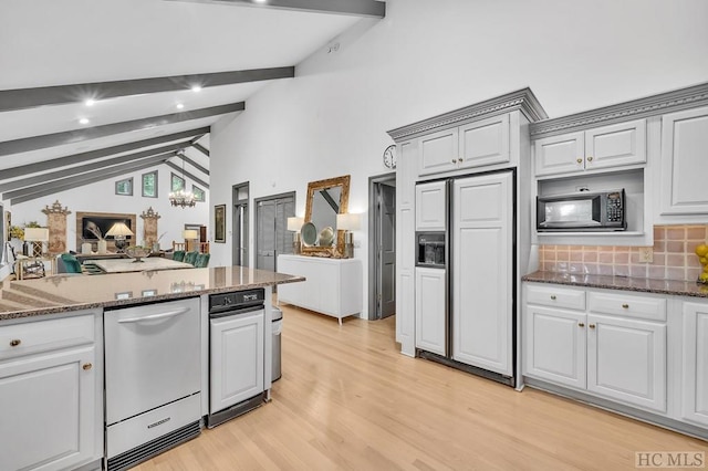 kitchen with built in appliances, decorative backsplash, lofted ceiling with beams, and dark stone countertops