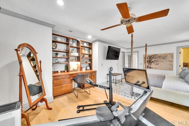 exercise area featuring heating unit, ornamental molding, and light hardwood / wood-style flooring