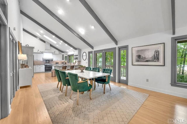 dining space featuring beamed ceiling, light wood-type flooring, and high vaulted ceiling