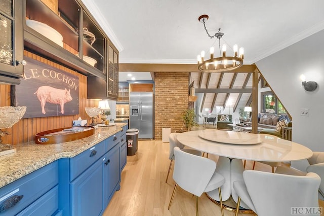 kitchen featuring a notable chandelier, light stone counters, blue cabinets, crown molding, and built in fridge