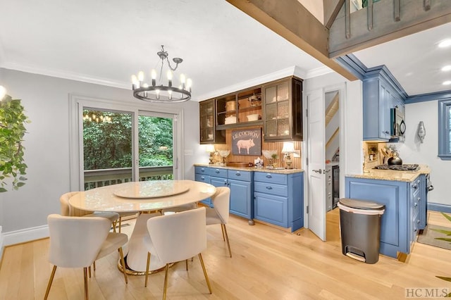 dining space featuring ornamental molding, light hardwood / wood-style flooring, a notable chandelier, and beverage cooler