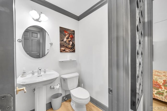 bathroom with toilet, hardwood / wood-style flooring, sink, and ornamental molding