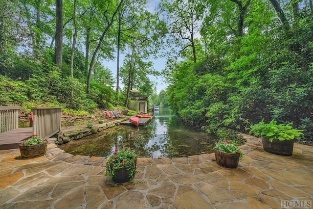 view of patio / terrace with a water view and a storage shed