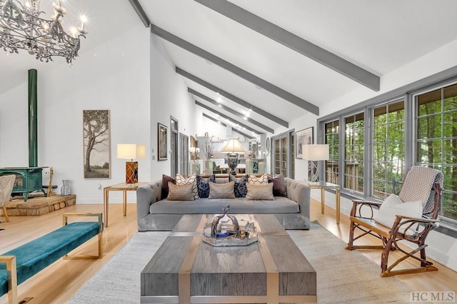 living room featuring beamed ceiling, a wood stove, and light hardwood / wood-style flooring