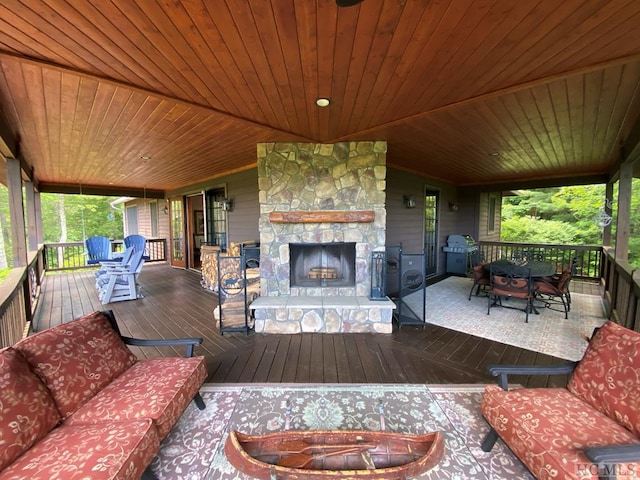 deck with a grill and an outdoor living space with a fireplace