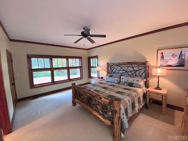 carpeted bedroom with ornamental molding and ceiling fan