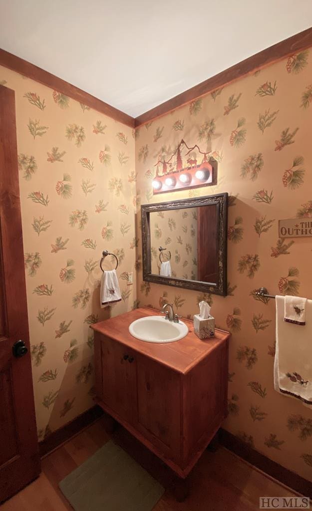 bathroom featuring vanity, wood-type flooring, and ornamental molding