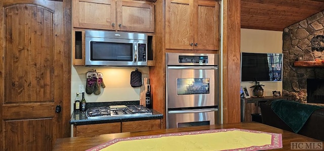 kitchen with vaulted ceiling, wooden ceiling, and appliances with stainless steel finishes