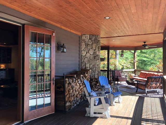 wooden terrace with ceiling fan, a porch, and an outdoor living space