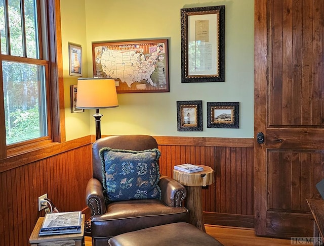 living area featuring a healthy amount of sunlight and wooden walls