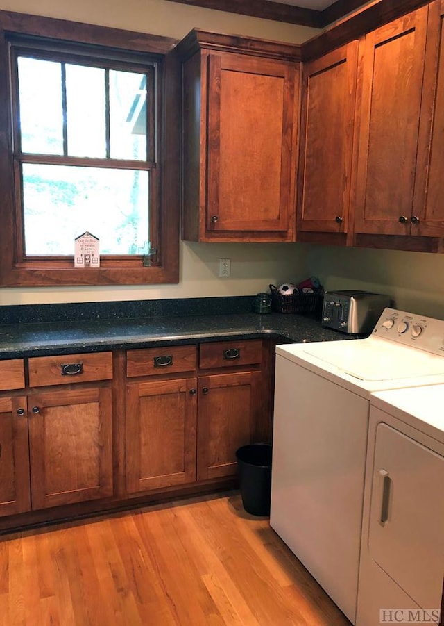 washroom with cabinets, washer and clothes dryer, and light hardwood / wood-style floors