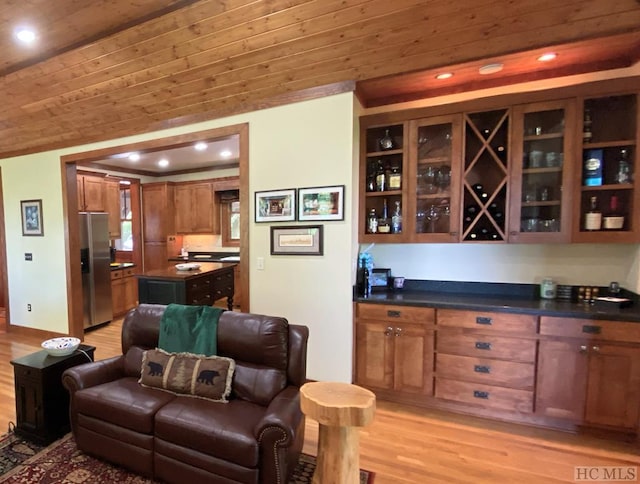 bar featuring light hardwood / wood-style flooring, wood ceiling, and stainless steel fridge