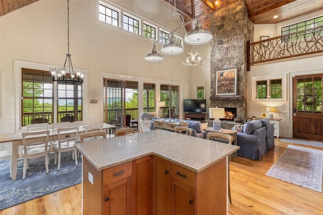 50 Bluestar Way, Glenville, NC 28736 - kitchen with high vaulted ceiling, a wood ceiling with exposed beams, a chandelier, light wood-style floors, and a stone fireplace