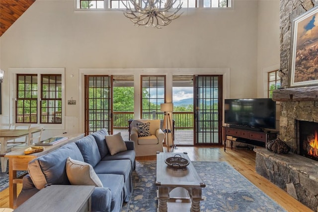 50 Bluestar Way, Glenville, NC 28736 - living room with high vaulted ceiling, a chandelier, hardwood / wood-style flooring, a stone fireplace, and wooden ceiling
