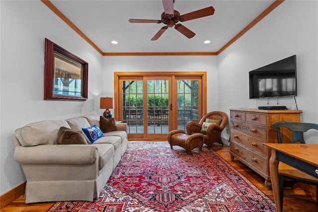 living area featuring crown molding, wood finished floors, a ceiling fan, baseboards, and recessed lighting