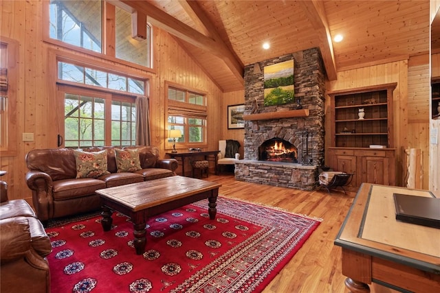 living room featuring high vaulted ceiling, wooden walls, wood finished floors, a fireplace, and beam ceiling