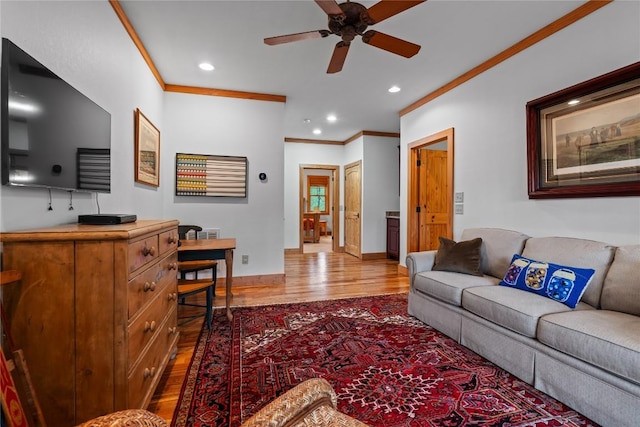 living area with ornamental molding, wood finished floors, a ceiling fan, recessed lighting, and baseboards