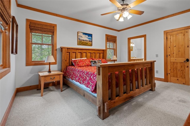 bedroom featuring carpet, baseboards, crown molding, connected bathroom, and ceiling fan