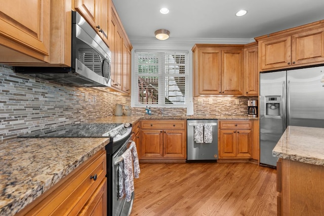 410C Highlands Cove Dr Unit 1300C, Highlands, NC 28741 - kitchen featuring stainless steel appliances, backsplash, light wood finished floors, light stone counters, and brown cabinetry