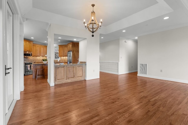 410C Highlands Cove Dr Unit 1300C, Highlands, NC 28741 - unfurnished living room with a chandelier, wood finished floors, recessed lighting, a tray ceiling, and ornamental molding