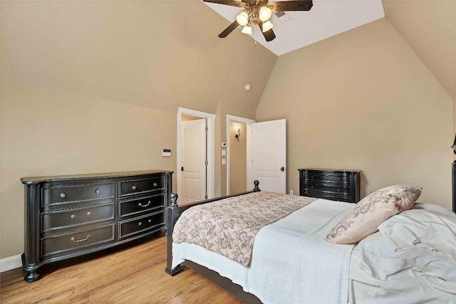 bedroom featuring light wood-type flooring, baseboards, high vaulted ceiling, and a ceiling fan