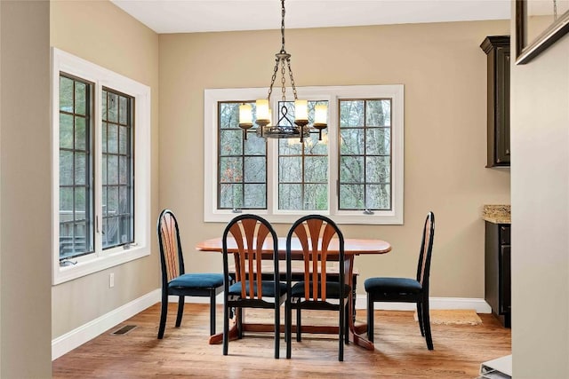 dining room featuring visible vents, a chandelier, light wood-style flooring, and baseboards