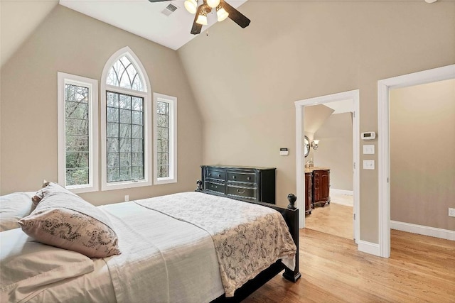 bedroom with light wood finished floors, baseboards, visible vents, a ceiling fan, and lofted ceiling