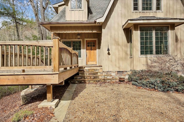 doorway to property featuring a shingled roof, crawl space, a wooden deck, and board and batten siding