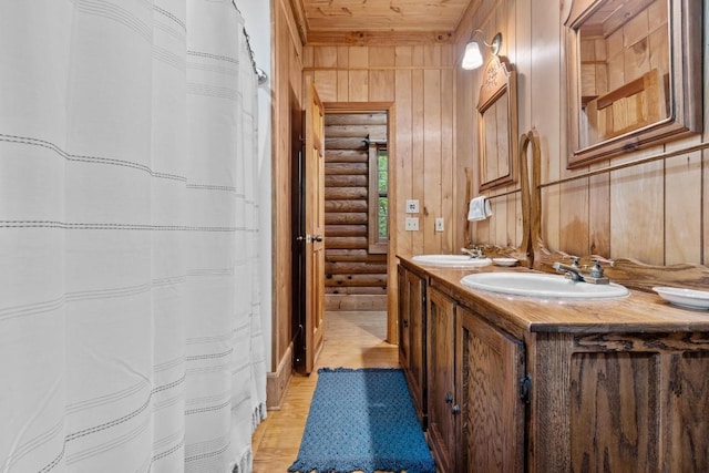 130 Sarah Cove Rd, Otto, NC 28763 - bathroom featuring rustic walls, wood finished floors, double vanity, and wood walls