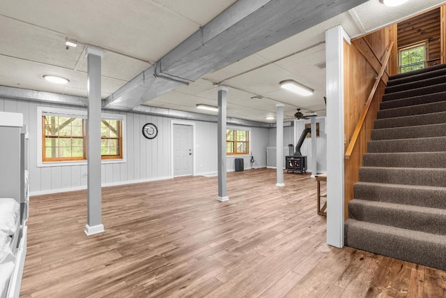 130 Sarah Cove Rd, Otto, NC 28763 - basement with a wood stove, wood finished floors, stairs, and baseboards