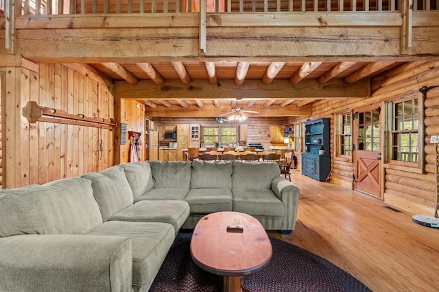 130 Sarah Cove Rd, Otto, NC 28763 - living room with wooden walls, wood finished floors, log walls, ceiling fan, and wood ceiling with exposed beams